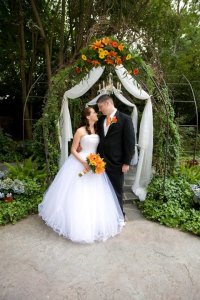 bride and groom with arch decor